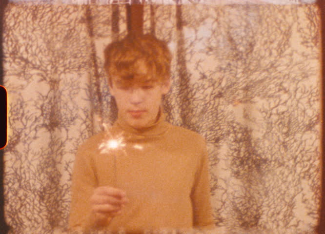 Teenager celebrates their 14th birthday with a sparkler, capturing the moment in a vintage, nostalgic style, evoking a sense of retro charm and youthful joy