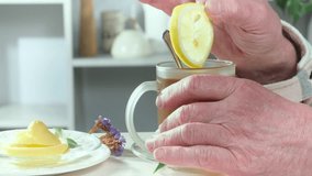 Male hands putting lemon into tea before drinking a cup of tea. Close-up. Slow motion. - Powered by Shutterstock - Get 15% off with code: PIKWIZARD15