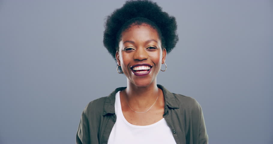 Woman, happy and joke or laughing, face and studio by gray background, funny and comedy in mockup. Black female person, portrait and comic or silly, goofy and freedom in positive mindset with smile