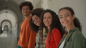 Group happy diversity students in university corridor talking smiling laughing four multiracial friends in college African American man guy with Arabian Hispanic women girls looking to camera positive - Powered by Shutterstock - Get 15% off with code: PIKWIZARD15