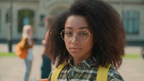 Portrait peaceful serious African American ethnic woman female girl student posing in city looking at camera outdoors studying education lonely learning talking students background school university - Powered by Shutterstock - Get 15% off with code: PIKWIZARD15