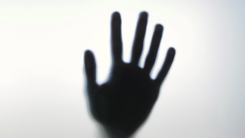 Blurred human hand gradually gaining sharp focus behind frosted glass panel, creating mysterious shadowy silhouette against pristine white background