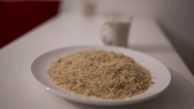 Close-up of traditional reviro dish placed in a white bowl, with textured grains in focus and a milk glass blurred in the background — captured in a slow motion orbit shot with soft depth - Powered by Shutterstock - Get 15% off with code: PIKWIZARD15