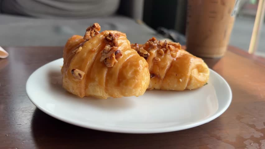 Cutting Into a Chocolate Cream-Filled Croissant at a Cafe with a Cup of Coffee 