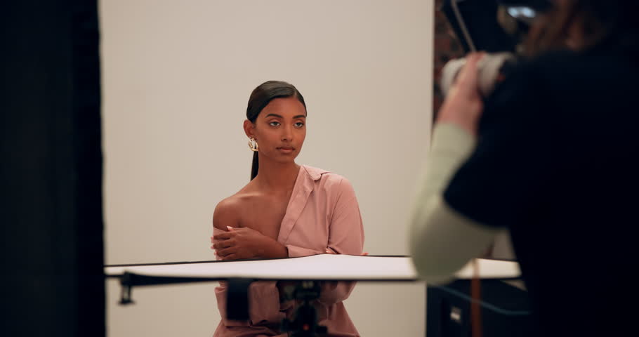 Woman, fashion model and camera with photography in studio for luxury, designer or clothing brand. Production, company and photographer with photoshoot flash for clothes, magazine or creative project