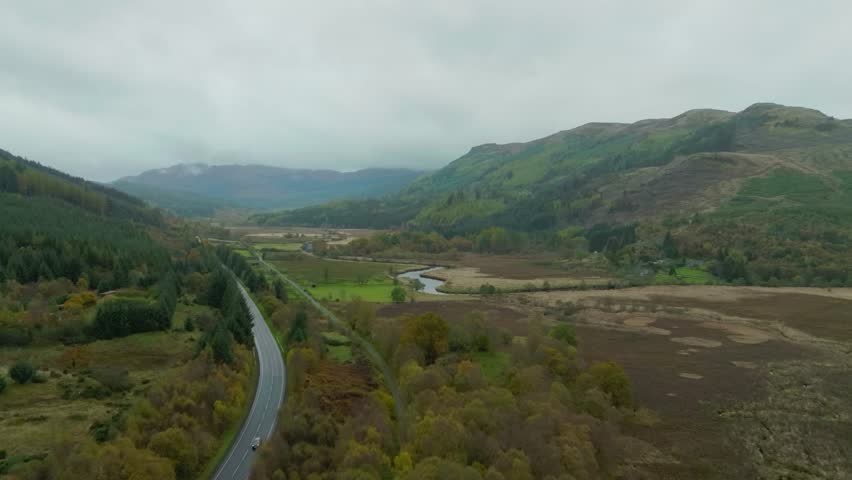 Stunning road through Scottish Highland valley, aerial shot over scenic route