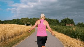 Woman jumping rope at sunrise on a countryside road and moving away from the camera. Blonde woman in her 40s, in a sports outfit jumping rope and moving forward
 - Powered by Shutterstock - Get 15% off with code: PIKWIZARD15