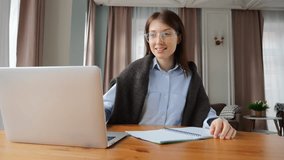 A woman works intently on her laptop in a sunlit, cozy room, taking notes. - Powered by Shutterstock - Get 15% off with code: PIKWIZARD15