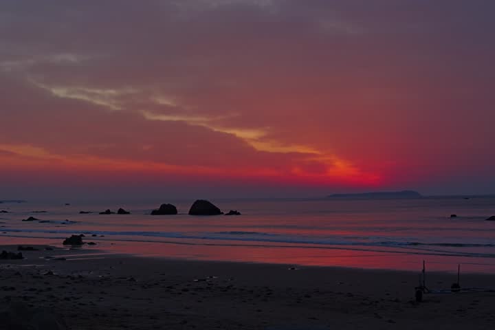 A serene sunset over the ocean, with warm hues of orange and pink blending into a calm beach,Time-lapse video of the sunrise over the sea,4k