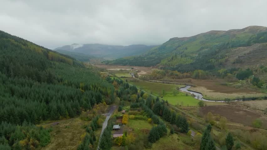 Road through Scottish Highland valley, high aerial shot