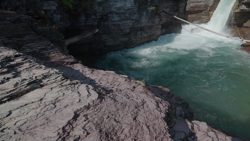 Majestic waterfall rushes into turquoise pool at St Mary Falls, Montana, summer scene