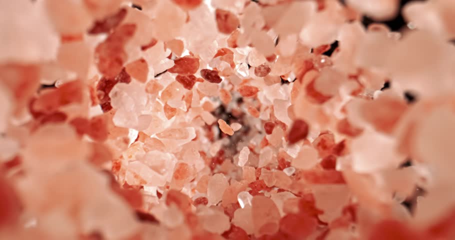 Himalayan pink salt is fallingin a super slow motion. Pink Himalayan salt is up to twenty times more expensive than table or sea salt. Shot on super slow motion camera 1000 fps.