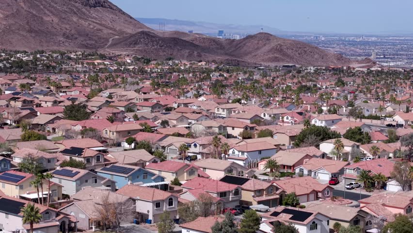 Neighborhood in Henderson, Nevada, suburb outside of Las Vegas revealing the Strip, aerial rising over mountain