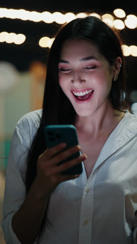 Vertical Video. Pretty Lady Winning the Money Online while Standing Outside. Hooray. Cute Female Celebrating Good News about Work in Restaurant. People and Technology Concept