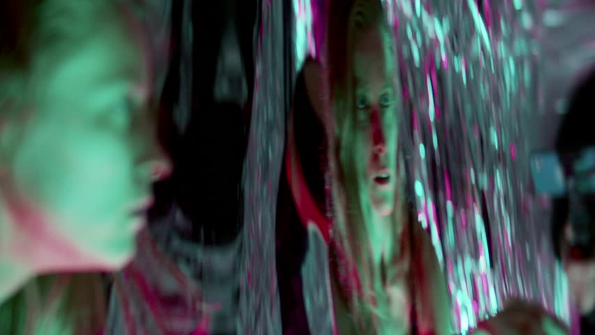 Emotional female dancer moving expressively through vibrant multicolored neon light, surrounded by distorted reflections, creating surreal and intense visual atmosphere