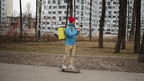 Skilled food delivery worker navigating city park pathway, riding skateboard while using smartphone app for managing online food delivery service - Powered by Shutterstock - Get 15% off with code: PIKWIZARD15