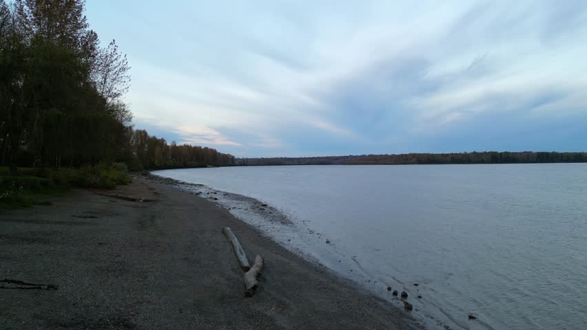 Calm River at Dusk With Driftwood on the Shore in BC, Canada