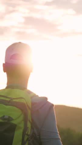 back view, happy man backpack raises hands up looking mountains, man backpack looks mountains sunset, climber resting day off, man hiking, man raises hands up sunset, male raises hands sky hike travel