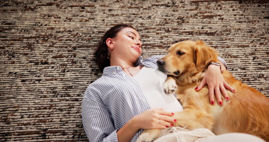 Above, dog and woman on floor, embrace and bonding together with weekend break. Home, pet and happy person on carpet, relaxing and comfortable with service animal, smile and chilling with support