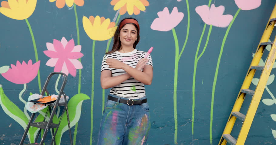 Face, happy and woman with graffiti painting for wall mural, community project and artistic freedom. Portrait, person or arms crossed for public art, flower design and local culture of creative hobby