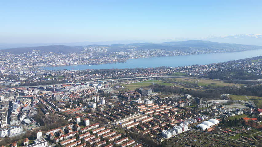 Aerial: Lake Zurich and cityscape from Friesenberg district during the day in Zurich, Switzerland, pan drone shot