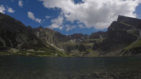 Time lapse of Czarny Staw in the Tatra Mountains with clouds drifting above steep cliffs and still mountain lake - Powered by Shutterstock - Get 15% off with code: PIKWIZARD15