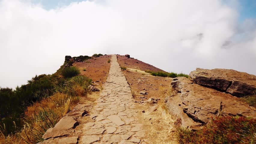 Path towards Pico Ruivo summit in Madeira, featuring rocky, stone-paved trail