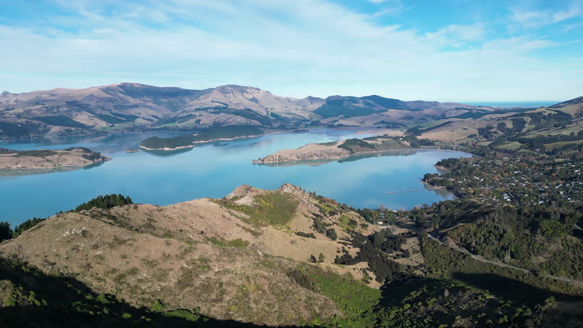 Scenic drone view of the Port Hills, near Christchurch, South Island, New Zealand. Clear blue sky and rugged hills in daylight.