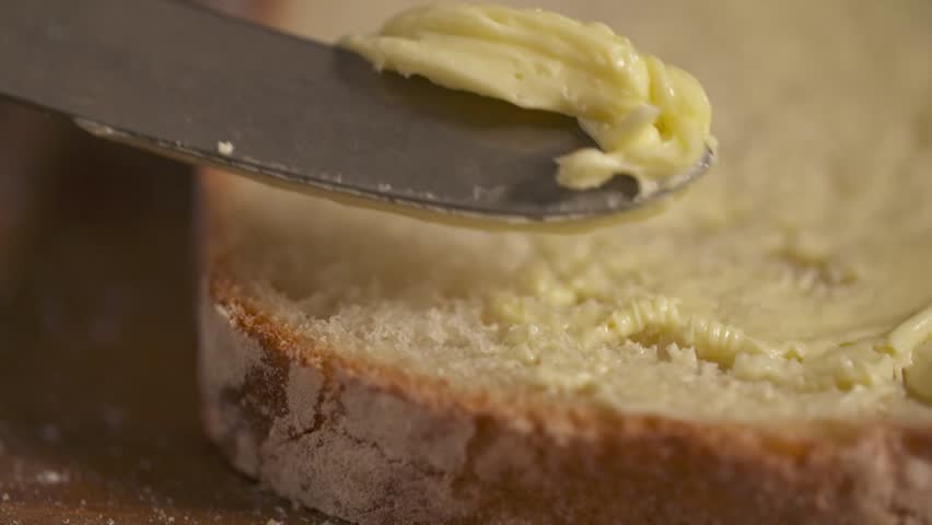 Butter Spreading onto a Slice of Bread
