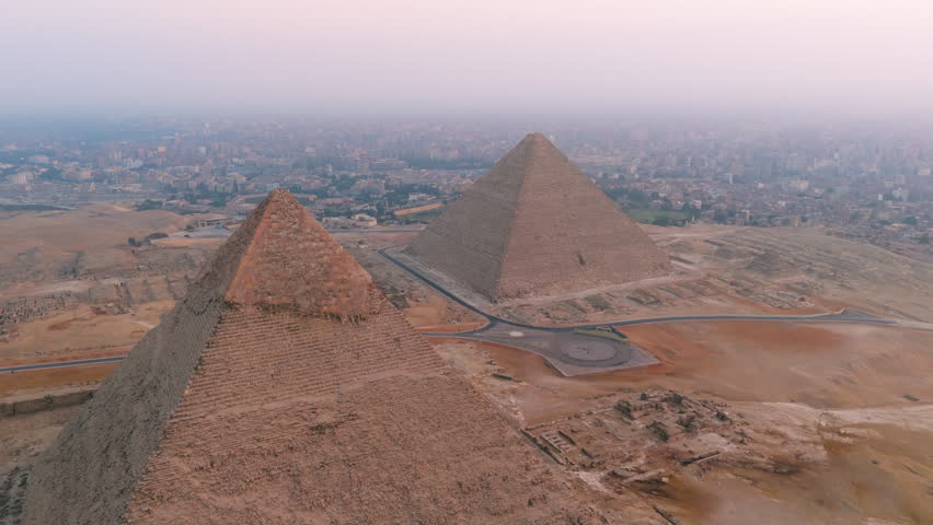 Pyramid Of Khafre And The Great Pyramid Of Giza With Foggy Background. Giza Pyramid Complex In Cairo, Egypt. aerial orbiting shot