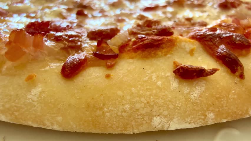 This closeup photo showcases a delicious pizza with crispy toppings and a beautifully golden crust