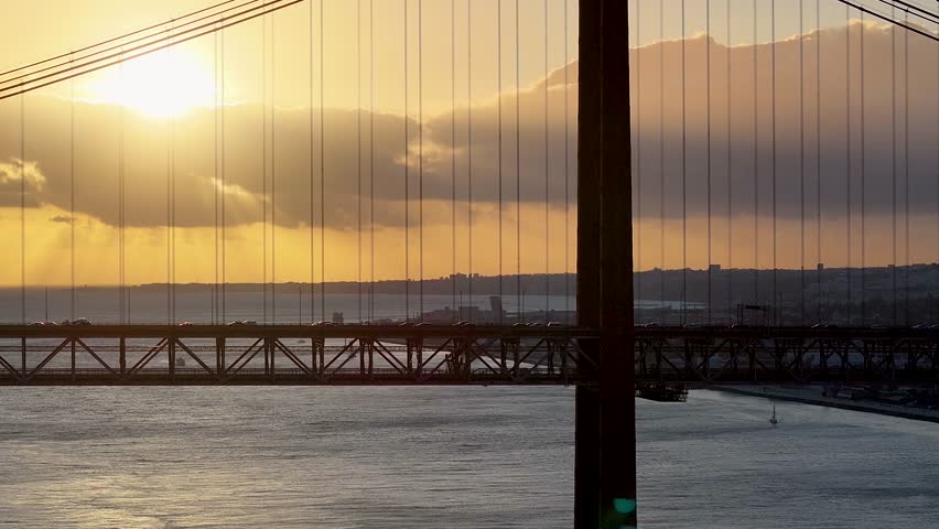 Sunset Sky Over 25 Of April Bridge At Lisbon In Lisbon District Portugal. Sunset Downtown. Freeway Road Landscape. 25 Of April Bridge At Lisbon In Portugal. Cable Stayed Bridge Scenery.