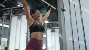 Young asian sportswoman focuses on back muscles during lat pulldown exercise, demonstrating strength and dedication to fitness goals in modern gym environment - Powered by Shutterstock - Get 15% off with code: PIKWIZARD15