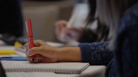 Close up hand of a person taking notes, writes with a pen on paper in notebook during lecture in seminar audience. A person is writing on document with pen. Planning, taking notes, writing reports - Powered by Shutterstock - Get 15% off with code: PIKWIZARD15