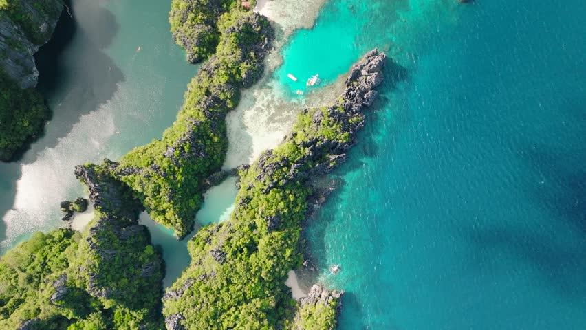 Aerial view of tropical lagoons with sunlight reflections surrounded by limestone formations. Miniloc Island. El Nido, Philippines.