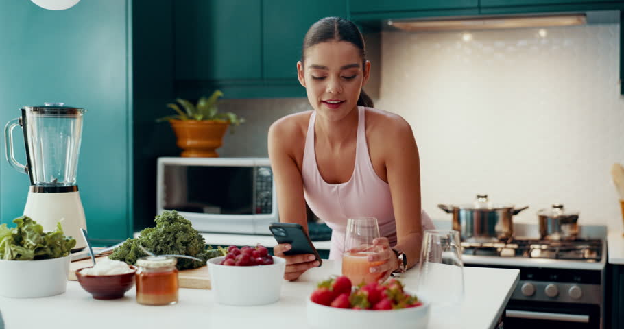Blender, juice and phone with woman in kitchen for smoothie recipe, food blog and nutritionist. Wellness, breakfast and detox diet with person at home for cooking, weight loss and protein shake