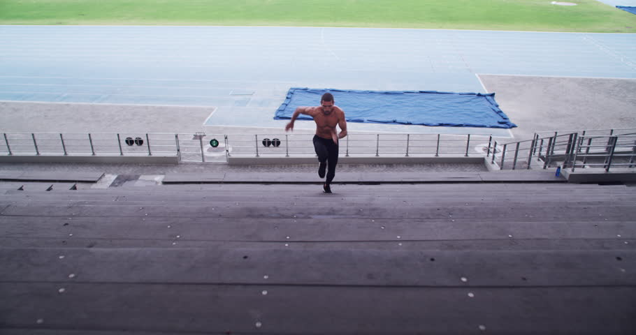 Runner, winner and athlete for training on stand, commitment and fitness for sprinting competition. Usa man, victory and wellness for confident in sport, outdoor exercise and strong body in stadium