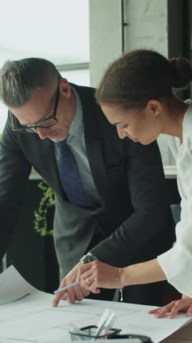 Architects discussing floor plan in modern office