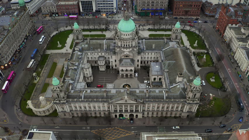 Static aerial shot of Belfast City Hall, traffic flowing around its grand architecture