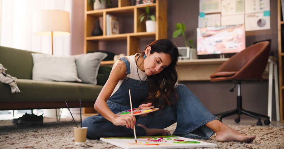 Woman, art and painting with brush on floor for creative development or design at home. Female person, artist or painter with canvas for colorful creativity, emotion or artistic expression at house