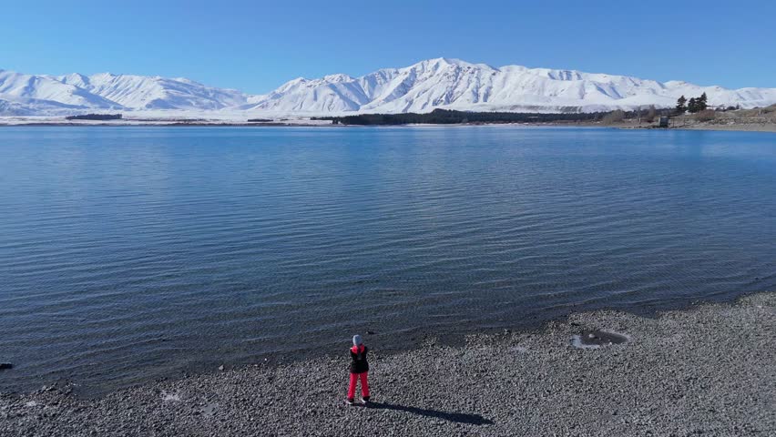 Sportive woman stands on shore admiring beauty of lake