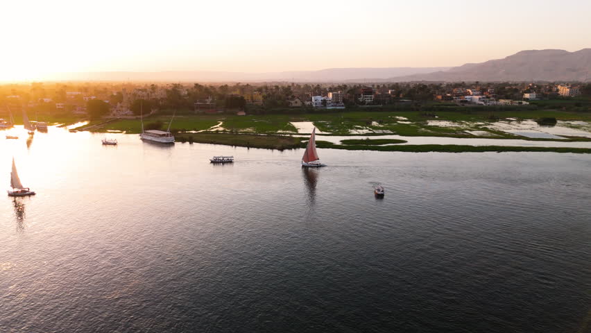 Traditional Felucca Boat Sails On The Nile River In Luxor, Egypt. Aerial Drone Shot