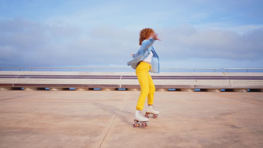 Happy young woman roller skating  and dancing outdoor in the city.