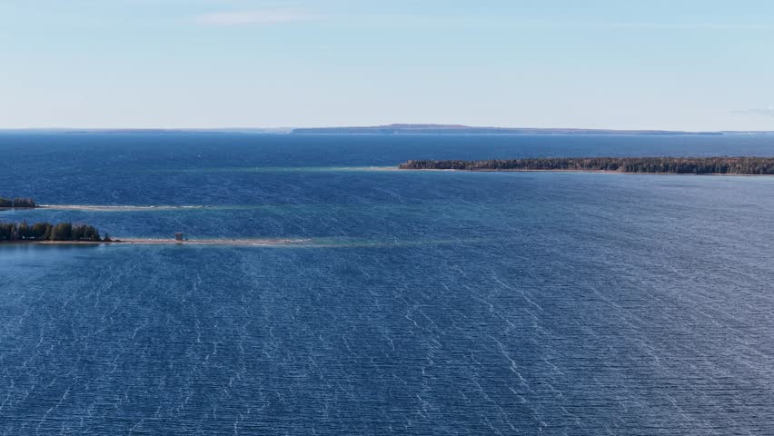 Wide aerial view of Lake Superior’s vast blue waters and forested shoreline in Michigan’s Upper Peninsula