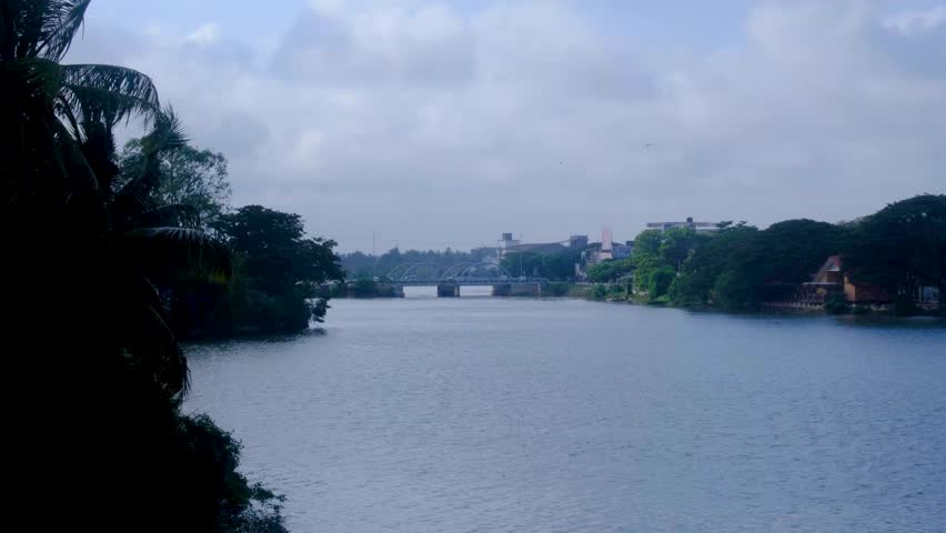 Scenic water view of busy traffic driving across bridge over lagoon in Batticaloa in eastern Sri Lanka