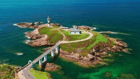 Aerial view of Faro de Ribadeo lighthouse in Lugo, Galicia, Spain. Scenic lighthouse on a rocky island on the Cantabrian Sea coast on a sunny summer day. - Powered by Shutterstock - Get 15% off with code: PIKWIZARD15