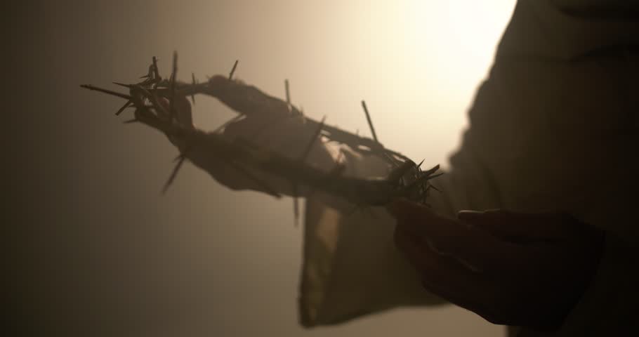 Jesus Christ holding a crown of thorns in ambient, glowing light as visual representation of good Friday and the crucifixion of Jesus on the cross. Perfect for Easter visual or gospel symbolism.