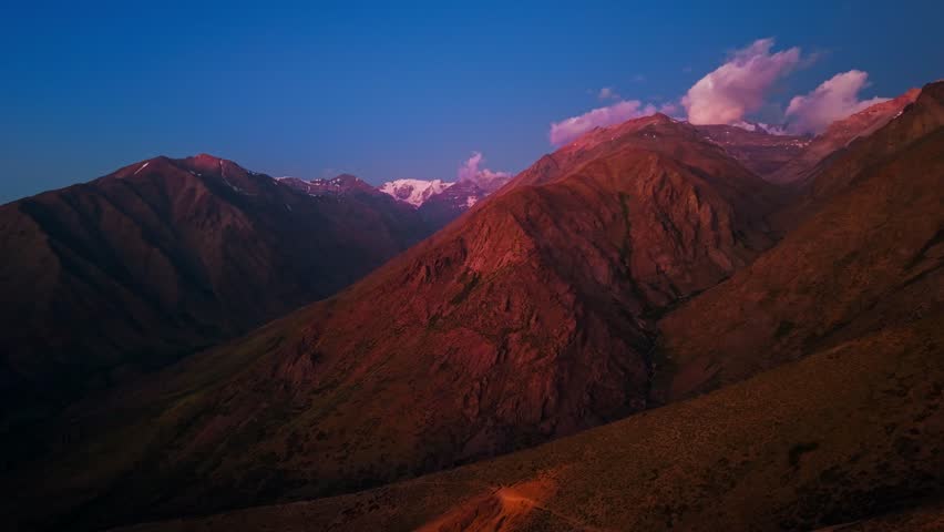 Nostalgic aerial view with orange mountains at sunset, solitude in the Andes Mountains, Yerba Loca park, Chile