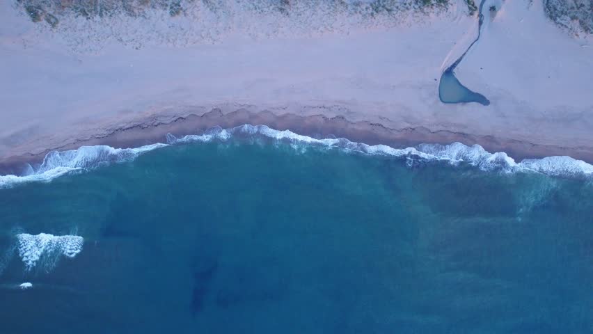 Mediterranean beach Aerial drone top down view of sea blue waves break and sand. Beautiful of sea water wave come to beach. Mesmerizing ocean waves sandy shoreline aerial top view. coastal landscape.