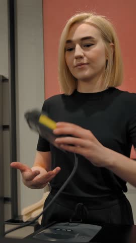 Female cashier passes terminal to pay for a client. Unrecognizable male's hand putting a credit or debit card for wireless payment. Middle shot of banking portable terminal operation. Vertical shot.